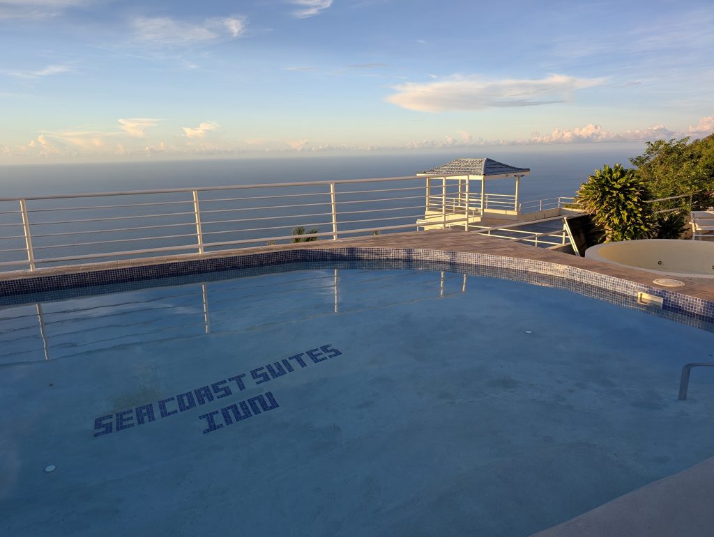 "Guest balcony at Sea Coast Inn overlooking Caribbean Sea and mountains”