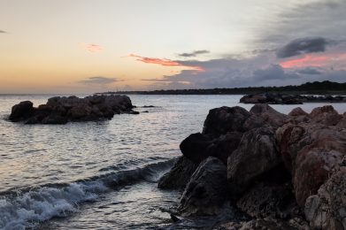 Golden sunset over Baileys Beach in St. Thomas, Jamaica with calm Caribbean waters.